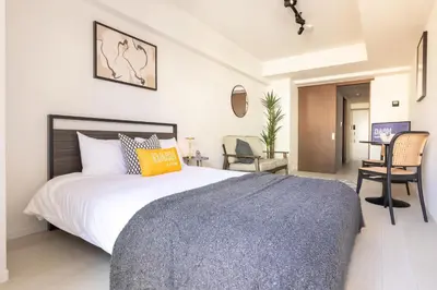 a bedroom with a large bed and a desk at Dash Living Ueno Park in Tokyo