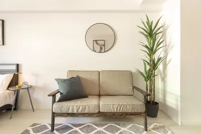 a living room with a couch and a mirror at Dash Living Ueno Park in Tokyo