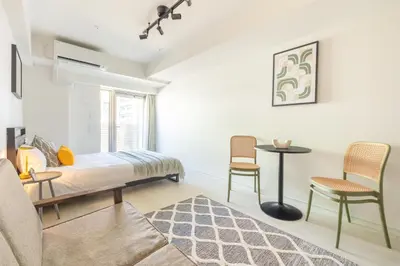 a bedroom with a bed and a table and chairs at Dash Living Ueno Park in Tokyo