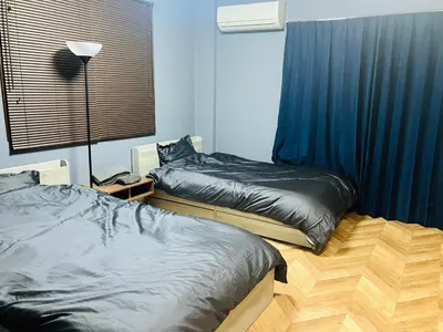 a bedroom with two beds and a lamp in it at 2nd house in Tokyo