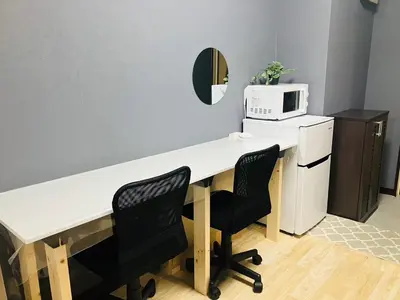 a white desk with two chairs and a microwave at 2nd house in Tokyo
