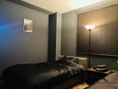 a bedroom with a bed and a lamp and a window at 2nd house in Tokyo