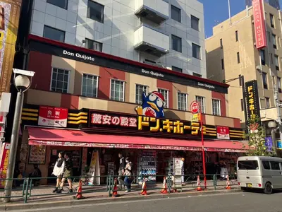 a building with a sign that reads dagon queues at 2nd house in Tokyo