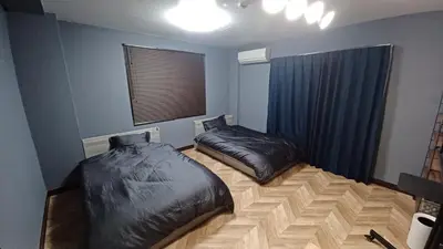 two beds in a room with blue walls at 2nd house in Tokyo