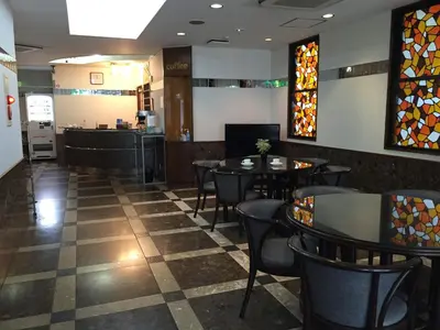 a restaurant with tables and chairs and stained glass windows at \u30a2\u30fc\u30d0\u30f3\u30db\u30c6\u30eb\u68ee\u4e0b in Tokyo