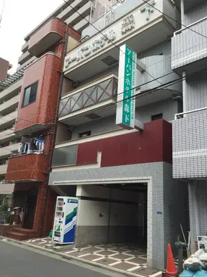 a building with a green sign in front of it at \u30a2\u30fc\u30d0\u30f3\u30db\u30c6\u30eb\u68ee\u4e0b in Tokyo