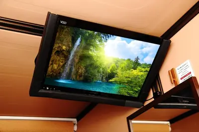 a flat screen tv hanging on a wall with a waterfall at Anshin oyado Tokyo Man Ginza Shimbashi Station in Tokyo
