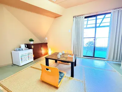 a living room with a table and a chair at Tokyo Holiday Hotel in Tokyo