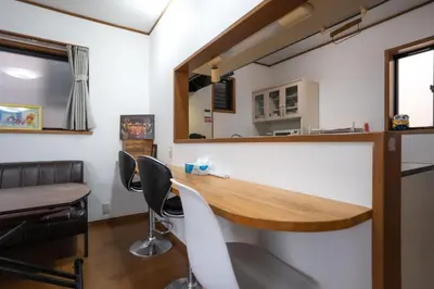 a room with a table and chairs and a counter at 7House in Tokyo