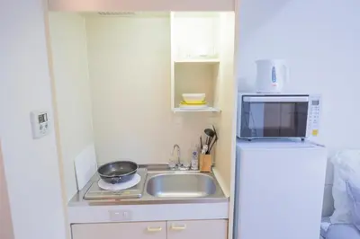 a small kitchen with a sink and a refrigerator at \u9591\u9759\u306a\u4f4f\u5b85\u8857_\u6696\u304b\u304f\u5c45\u5fc3\u5730\u306e\u826f\u3044\u30c7\u30b6\u30a4\u30f3 EoW-7 in Tokyo