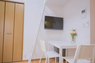 a room with a white table and a tv on a wall at \u9591\u9759\u306a\u4f4f\u5b85\u8857_\u6696\u304b\u304f\u5c45\u5fc3\u5730\u306e\u826f\u3044\u30c7\u30b6\u30a4\u30f3 EoW-7 in Tokyo