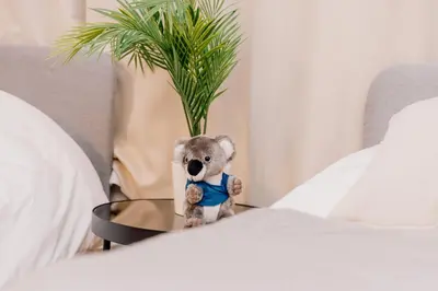 a teddy bear sitting on a table between two beds at Eminaz Minami Otsuka 2F in Tokyo