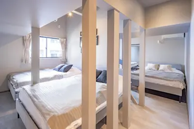 two beds in a room with mirrors in it at Eminaz Minami Otsuka 3F4F in Tokyo