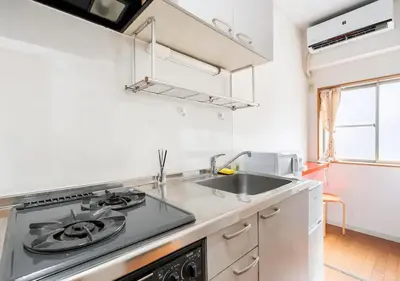 a kitchen with a stove and a sink at 101 Shinjuku Modern Apartment Triple Station Access Free Wi-Fi in Tokyo