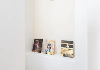 three pictures on a shelf in a white wall at 101 Shinjuku Modern Apartment Triple Station Access Free Wi-Fi in Tokyo