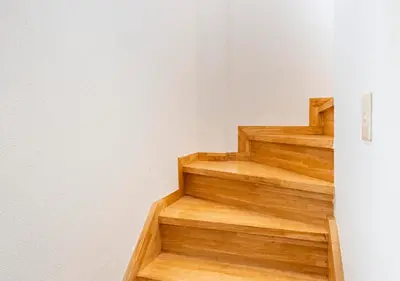 a wooden staircase in a room with a white wall at 101 Shinjuku Modern Apartment Triple Station Access Free Wi-Fi in Tokyo
