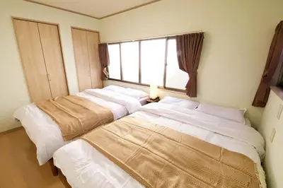 two beds in a room with a window at \u6885\u5c4b\u6577\u8cb8\u5bb6 in Tokyo