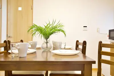 a wooden table with a vase with a plant on it at \u6885\u5c4b\u6577\u8cb8\u5bb6 in Tokyo