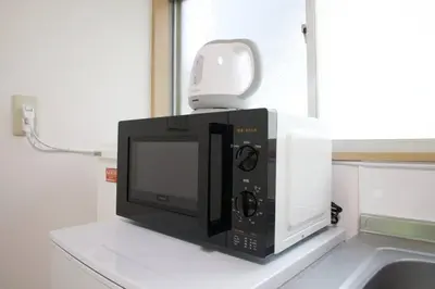 a microwave oven sitting on top of a counter at \u6885\u5c4b\u6577\u8cb8\u5bb6 in Tokyo