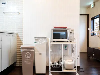 a microwave sitting on a cart in a kitchen at Shinjuku-Okubo sta, 3 min walk-Switch-Movie-Internet-Mobile Wi-Fi in Tokyo