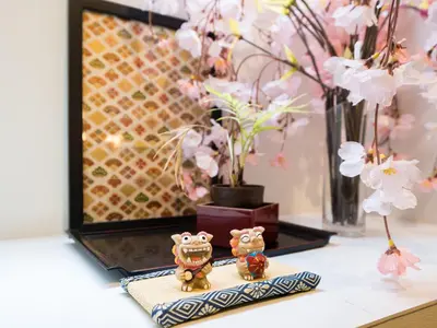 two figurines sitting on top of a table with flowers at Shinjuku-Okubo sta, 3 min walk-Switch-Movie-Internet-Mobile Wi-Fi in Tokyo