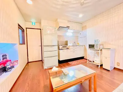 a living room with a table and a kitchen at Shinjuku-Okubo sta, 3 min walk-Switch-Movie-Internet-Mobile Wi-Fi in Tokyo