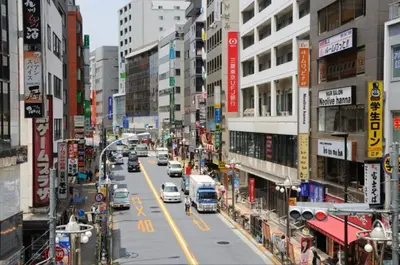 a busy city street with cars and buildings at 403, Shinjuku City, JR Yamanote Line, 6 min walk to stn in Tokyo