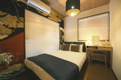 a bedroom with a bed and a desk with a computer at Ukiyoan Kachofugetsu in Tokyo