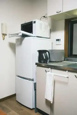 a white refrigerator with a microwave on top of it at Ukiyoan Kachofugetsu in Tokyo