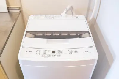 a white washing machine sitting in a room at walk to JR Shibuya sta.-SoE4 in Tokyo