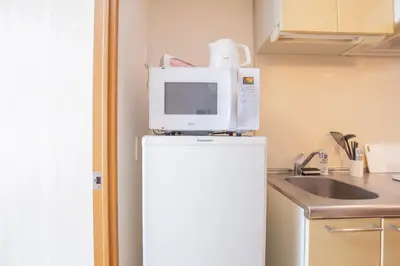 a microwave on top of a refrigerator in a kitchen at walk to JR Shibuya sta.-SoE4 in Tokyo