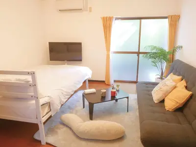 a living room with a bed and a couch at Lucky Yotsugi - \u30e9\u30c3\u30ad\u30fc\u56db\u30c4\u6728 in Tokyo