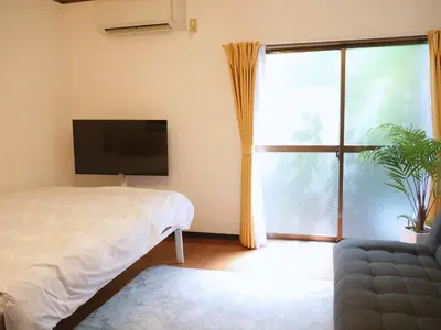 a bedroom with a bed and a large window at Lucky Yotsugi - \u30e9\u30c3\u30ad\u30fc\u56db\u30c4\u6728 in Tokyo