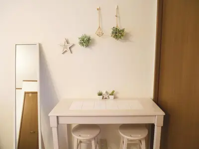 a white table with two stools in a room at Lucky Yotsugi - \u30e9\u30c3\u30ad\u30fc\u56db\u30c4\u6728 in Tokyo