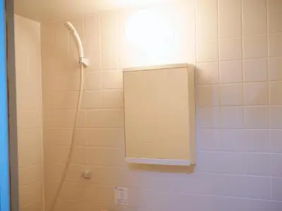 a bathroom with a shower and a mirror on the wall at Lucky Yotsugi - \u30e9\u30c3\u30ad\u30fc\u56db\u30c4\u6728 in Tokyo