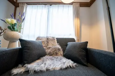 a dog sitting on top of a couch with pillows at Lucky Horikiri - \u30e9\u30c3\u30ad\u30fc\u5800\u5207 in Tokyo