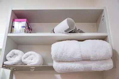 two towels and a box on a shelf with towels at KYARA HOTEL\u3000\u4e80\u6238502 in Tokyo