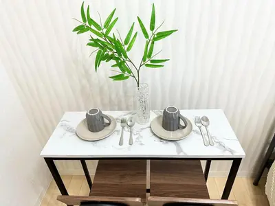 a table with two plates and a vase with a plant at A shinnjuku area \u5f92\u6b65\u5230\u65b0\u5bbf\u53ea\u9700\u898110\u5206\u949f\u5f92\u6b65\u5230\u65b0\u5927\u4e45\u4fdd\u53ea\u9700\u89814\u5206\u949f\u590d\u5f0f\u623f\u95f4a in Tokyo