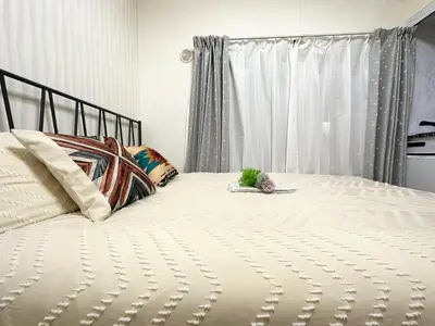 a bedroom with a bed with a white bedspread at A shinnjuku area \u5f92\u6b65\u5230\u65b0\u5bbf\u53ea\u9700\u898110\u5206\u949f\u5f92\u6b65\u5230\u65b0\u5927\u4e45\u4fdd\u53ea\u9700\u89814\u5206\u949f\u590d\u5f0f\u623f\u95f4a in Tokyo