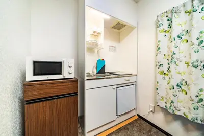 a small kitchen with a microwave and a refrigerator at 84-5, Shiomi 301, Entire room for rent, \u6f6e\u898bB301 in Tokyo