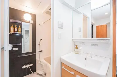 a bathroom with a sink and a toilet and a mirror at Six7 Asakusa Ryogoku in Tokyo