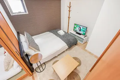 a small bedroom with a bed and a television at Six7 Asakusa Ryogoku in Tokyo