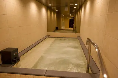 a walkway with a pool of water in a hallway at Anshin oyado Tokyo Man Akihabara in Tokyo