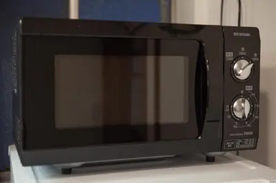 a black microwave oven sitting on top of a counter at Traditional House West Ikebukuro - \u30c8\u30e9\u30c7\u30a3\u30b7\u30e7\u30ca\u30eb\u30cf\u30a6\u30b9\u30a6\u30a7\u30b9\u30c8\u6c60\u888b in Tokyo