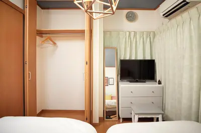 a bedroom with a bed and a tv and a dresser at Traditional House West Ikebukuro - \u30c8\u30e9\u30c7\u30a3\u30b7\u30e7\u30ca\u30eb\u30cf\u30a6\u30b9\u30a6\u30a7\u30b9\u30c8\u6c60\u888b in Tokyo
