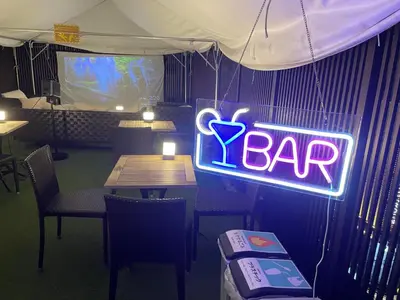 a neon bar sign hanging in a restaurant at Capsule Hotel Suzumoriya in Tokyo