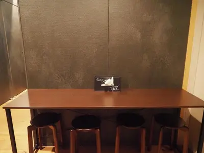 a wooden table with four stools around it at Capsule Hotel Suzumoriya in Tokyo