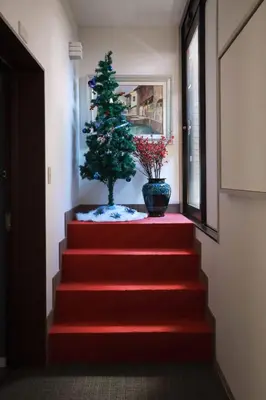a red carpeted staircase with a christmas tree on it at Hananoie\u83ef\u4e4b\u5bb6 in Tokyo