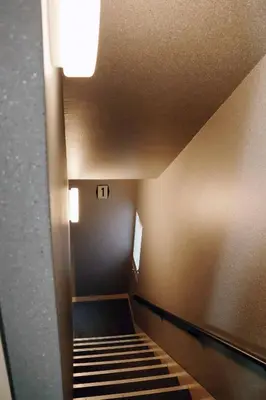 a staircase in a building with a light on the ceiling at Hananoie\u83ef\u4e4b\u5bb6 in Tokyo