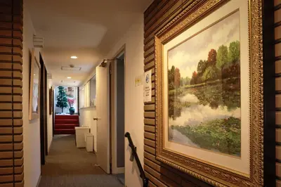 a painting hanging on a wall in a hallway at Hananoie\u83ef\u4e4b\u5bb6 in Tokyo